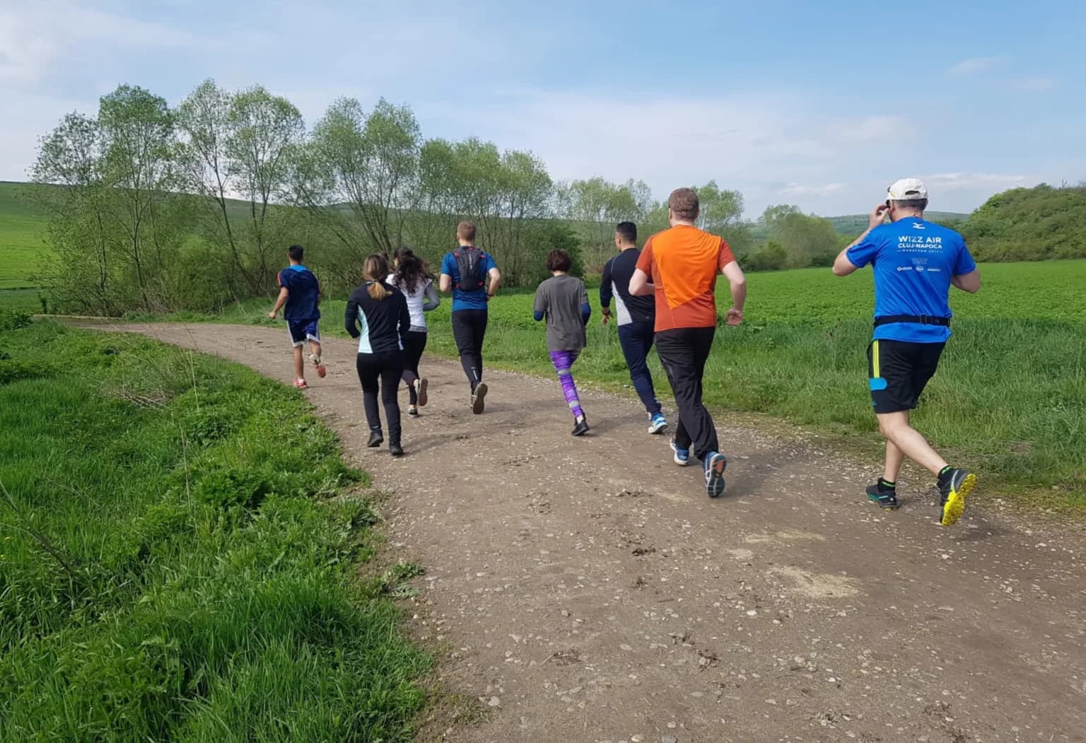 Participanți la cros alergând pe un drum de țară