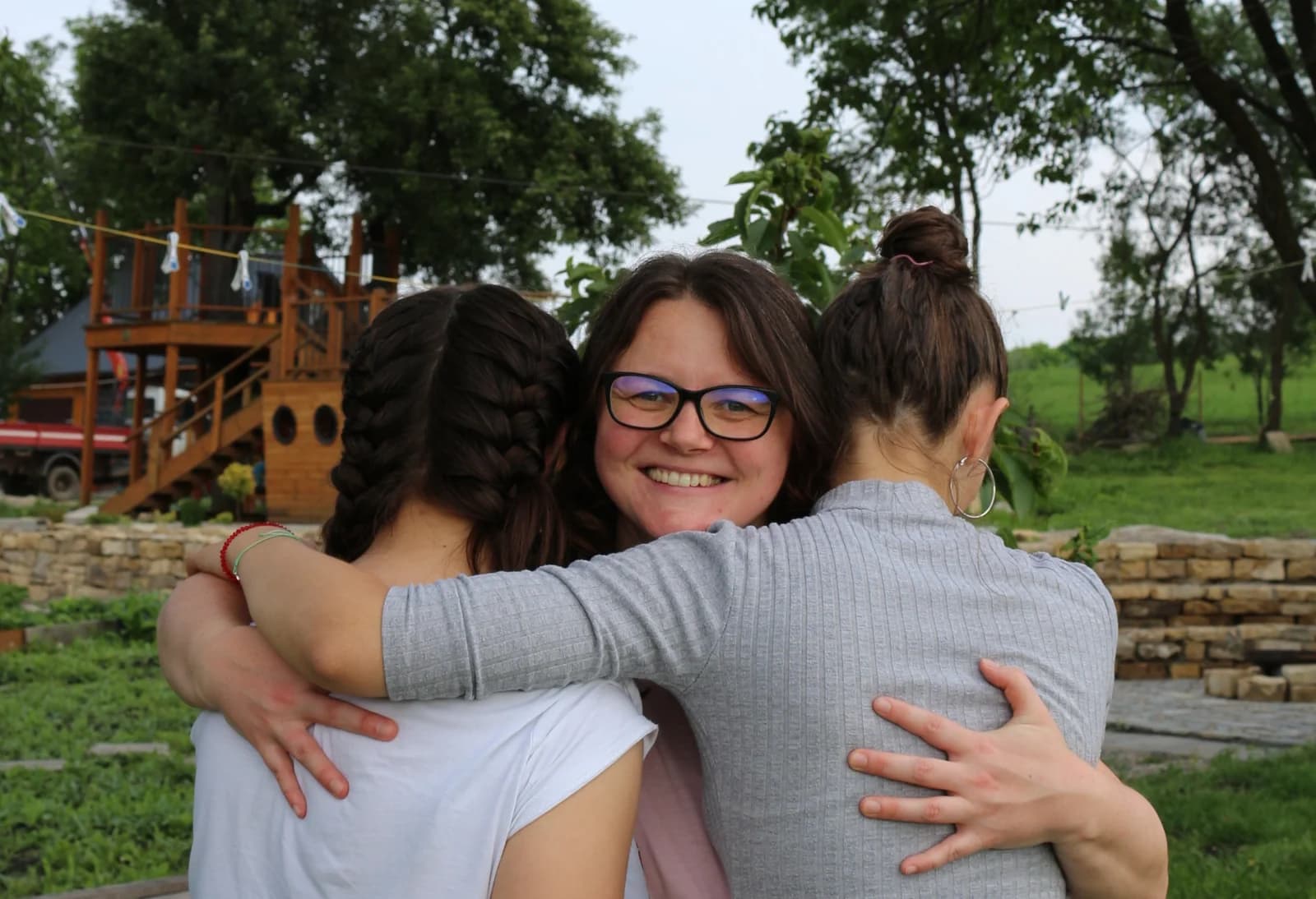 O îmbrățișare de grup între prieteni, în grădina de la Borșa